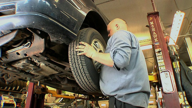 MS TU Auto机械师调整耳螺母后，在汽车修理厂/切尔西，密歇根州，美国视频下载