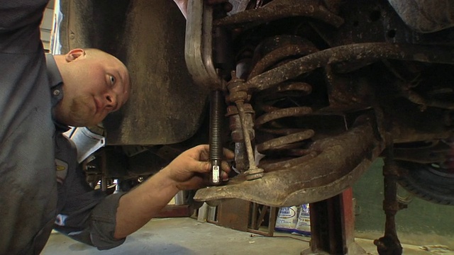 CU ZI汽车修理工在美国密歇根州切尔西汽车修理厂安装汽车上球接头时使用夹具视频下载