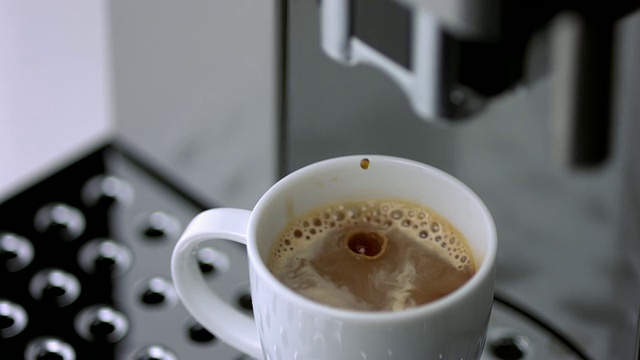 SLO MO CU SELECTIVE FOCUS咖啡从咖啡机滴入杯子视频下载