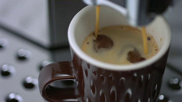 SLO MO ECU选择性聚焦咖啡从浓缩咖啡机滴入杯子视频下载