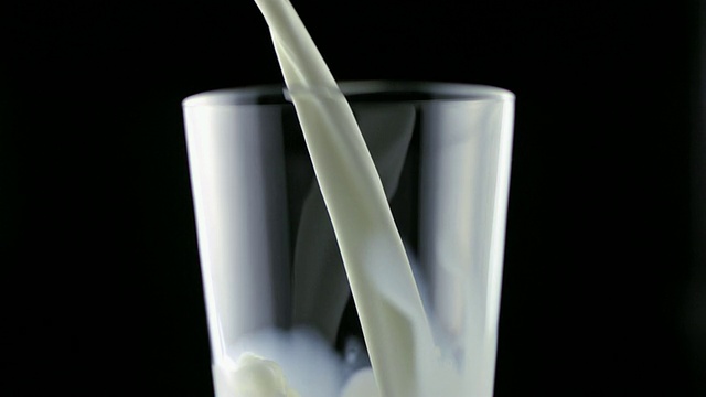 SLO MO MS Studio拍摄了在黑色背景下将牛奶倒入玻璃杯中的画面视频下载