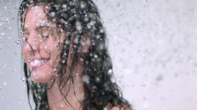 SLO MO CU工作室拍摄的年轻女子在淋浴时摇头视频素材