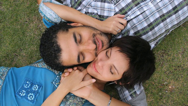 古巴哈瓦那，一对夫妻躺在草地上摩擦脸颊视频下载