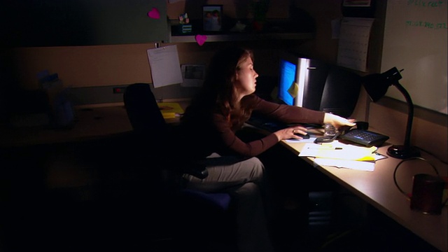 中景摄影拍摄了一个在小隔间工作到很晚/挂电话的女人视频下载
