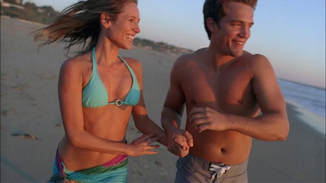 慢动作中镜头情侣在沙滩上跑步/接吻视频下载
