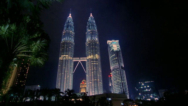 低角度广角拍摄双塔，和Menara Maxis在晚上/吉隆坡视频下载