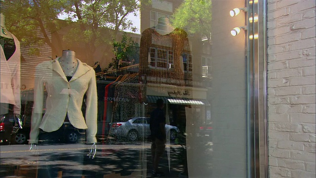 一个中等大小的女人走进一家服装店，看着橱窗展示/ Westfield，新泽西州视频下载