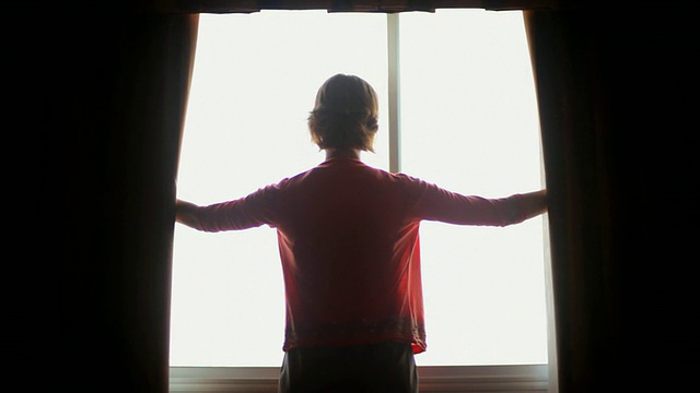 美国威斯康辛州麦迪逊市，一位年轻的女士正在拉开她房间的窗帘视频下载