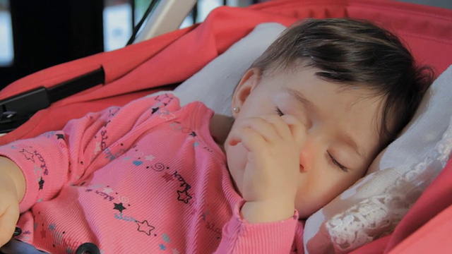 CU小女孩(6-11个月)睡在婴儿车里，吮吸拇指，然后把拇指从嘴里拿出来/迈阿密，佛罗里达，美国视频下载