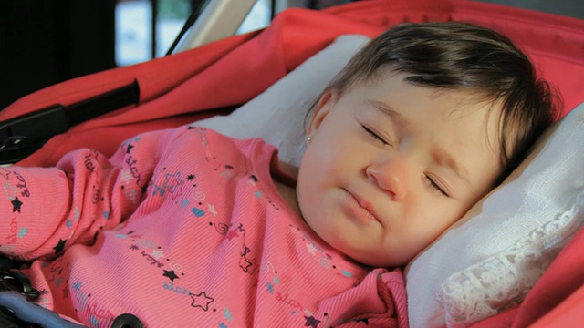 CU女婴(6-11个月)睡在婴儿车里，吮着她的拇指/迈阿密，佛罗里达，美国视频下载