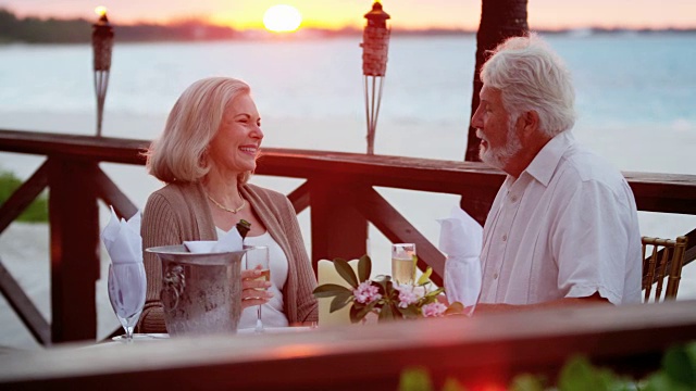相爱的老年白种夫妇享受浪漫的海滨餐厅视频素材
