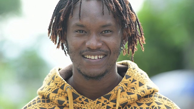 年轻快乐英俊的非洲男人在户外的街道上微笑视频素材
