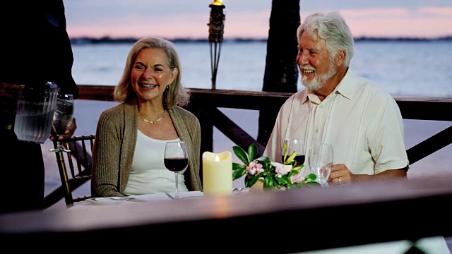 浪漫的白人老年夫妇享受傍晚海滨餐厅视频素材