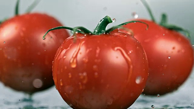 三个湿的西红柿掉在桌子上视频素材