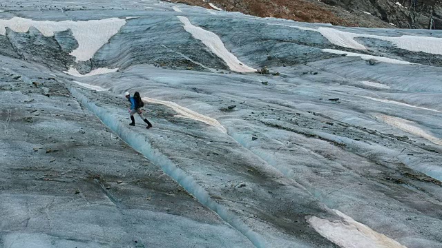 一名极端徒步者在瑞士伯尔尼斯阿尔卑斯山徒步穿越又深又宽的著名冰川阿莱奇冰川，这是欧洲最长最大的冰川。视频下载