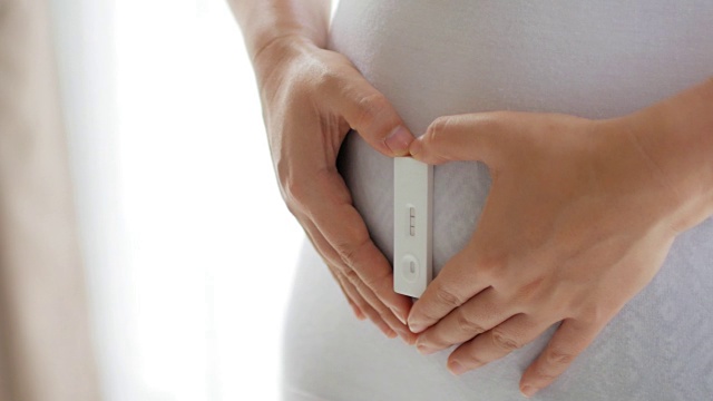用验孕棒抱着肚子的孕妇视频素材