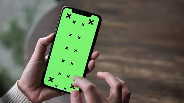 女人用绿色屏幕的手机视频下载