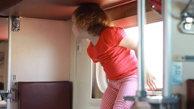 那个小女孩正在乘火车旅行。婴儿乘火车旅行，准备睡觉。视频下载