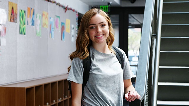 女高中生站在教学楼楼梯旁的肖像视频素材