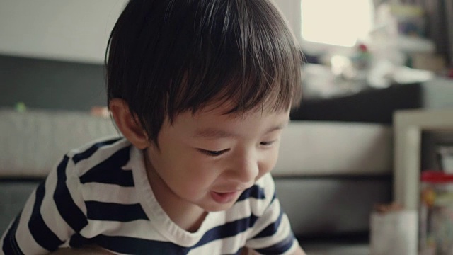 亚洲小男孩在家里玩玩具视频素材