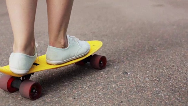 十几岁的女孩脚骑短现代滑板视频素材