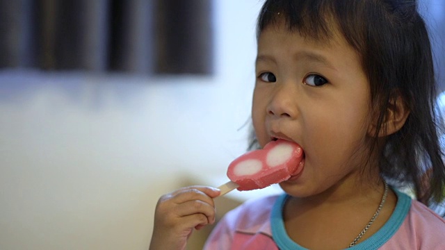 穿粉红色t恤吃粉红色冰淇淋的女孩。视频素材