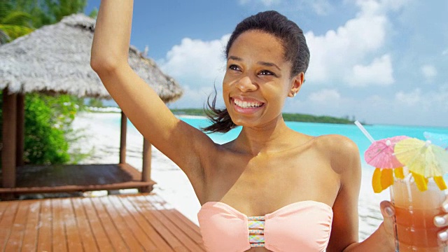 非裔美国女孩在海滩上喝着鸡尾酒视频素材