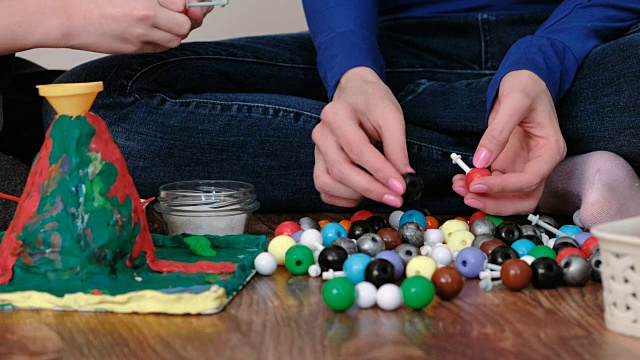 特写手的妈妈和儿子建设分子模型的彩色塑料建设集。视频下载
