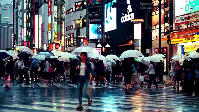 在雨中，黄昏时分，涉谷人群撑着伞过马路视频下载
