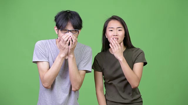 年轻的亚洲夫妇看起来震惊在一起视频下载