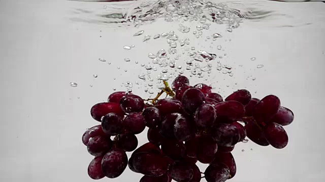 用慢镜头拍摄红葡萄。一大串成熟的葡萄泡在水里。视频下载