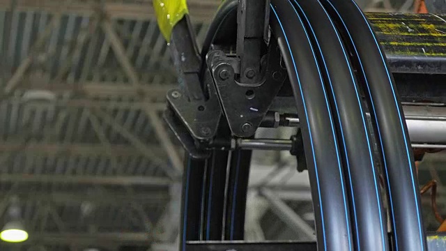 卷螺纹盘管。生产塑料水管的工厂。用水和空气的压力在机床上制造塑料管的工艺。视频素材