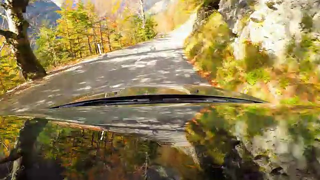 驱车沿着蜿蜒的山路穿过秋天的森林视频素材