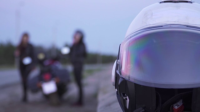 在模糊的背景下，两名女骑手准备骑摩托车视频下载