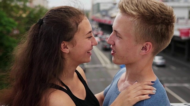 年轻快乐的女孩在夏天的城市里温柔地拥抱她的男朋友视频下载