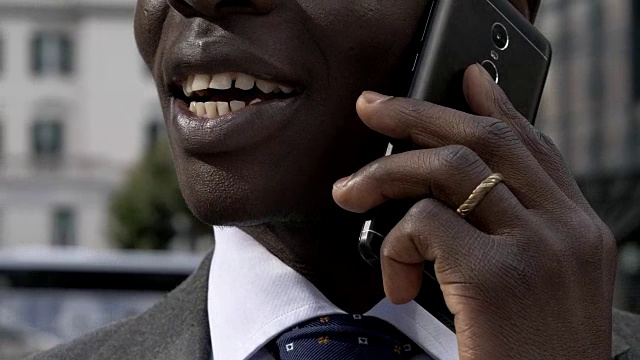 非洲黑人商人在城市里通过电话交谈-特写视频素材