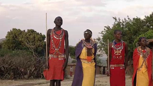 用镜头摇摄一群马赛男女在一个村庄里唱歌跳舞视频素材