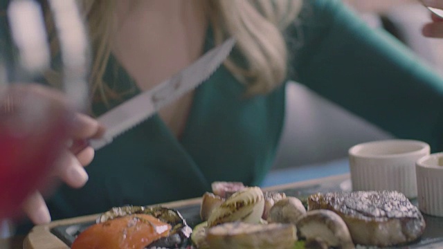 女人在餐馆吃牛排的慢镜头视频素材