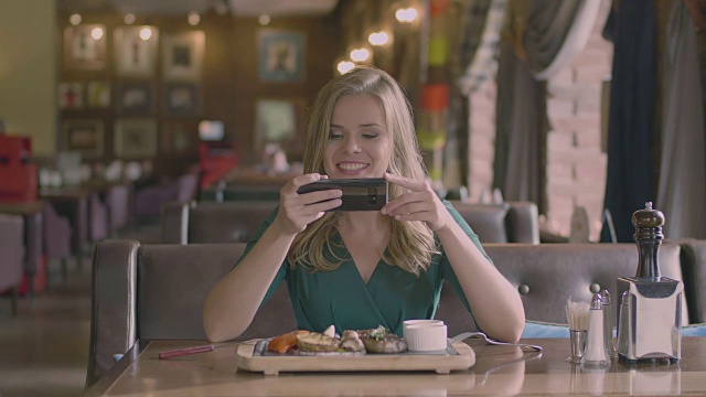 微笑的女人使牛排在餐厅的照片视频素材