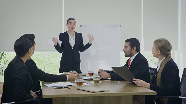 年轻的女商人在会议室向他的同事展示展示视频素材
