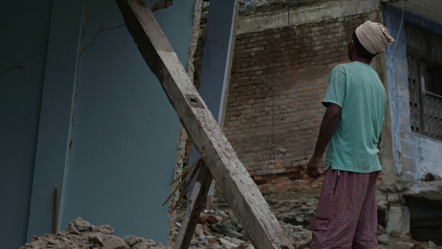 2015年7月31日，尼泊尔巴拉比斯:一名男子站在被摧毁的房屋前视频素材