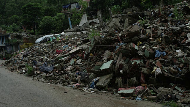 2015年7月31日，尼泊尔Barabise:街道上的房子变成了瓦砾，摩托车经过视频素材