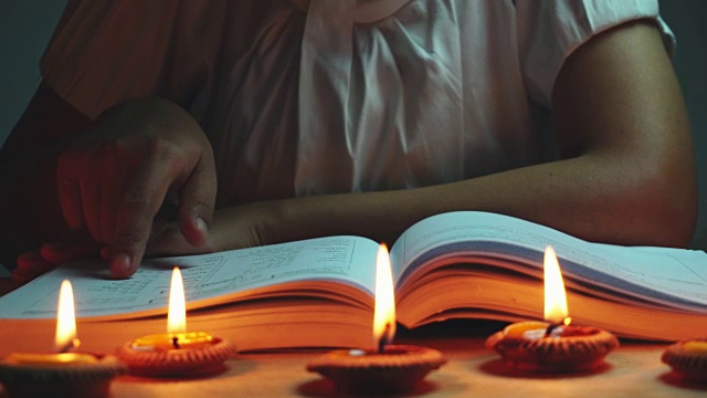 多利女人在许多蜡烛的照耀下看书。视频素材