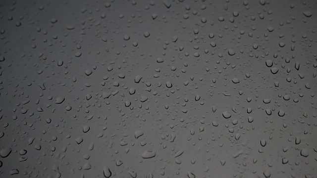 雨滴落在窗玻璃上，沿着玻璃流动。视频素材