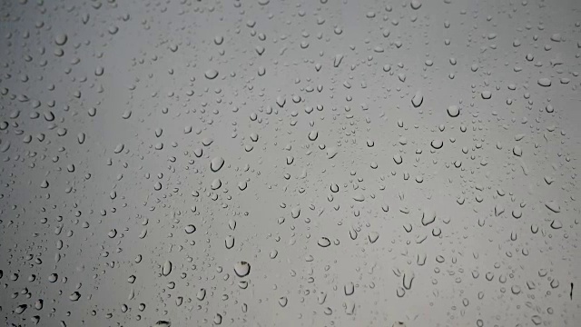 大量的雨水打在窗玻璃上。全景图向右移动。视频素材