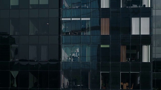 鸟瞰图镜头:从外面到办公大楼与商人工作和看窗外。美丽的飞走的金融商业区摩天大楼。视频素材