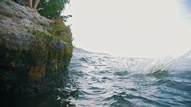 一个人在大自然中度假时，在河里跳了个魔术，动作很慢视频素材