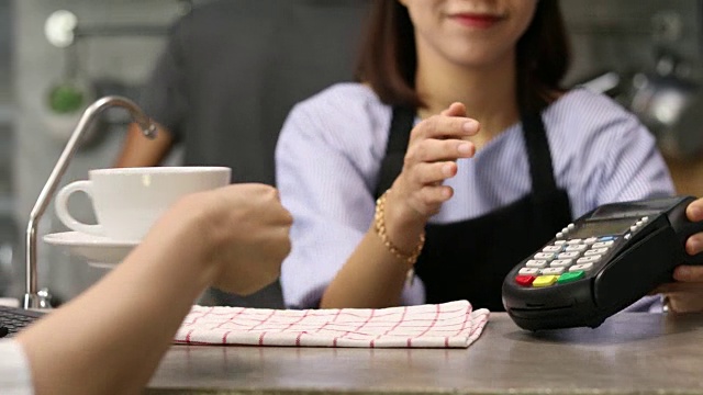 一位女士在咖啡店用手机为外卖咖啡买单视频素材