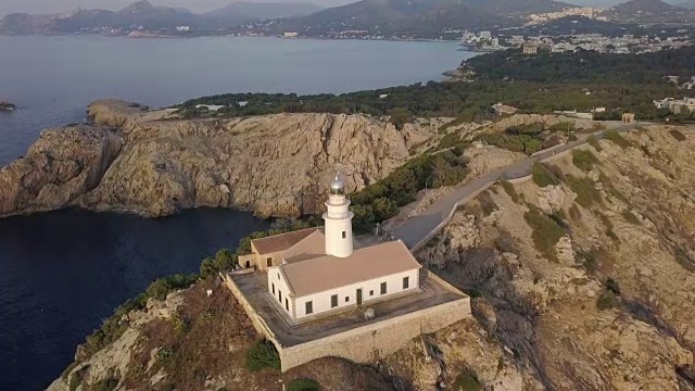 日出时马略卡岛石崖上灯塔的航拍图视频素材