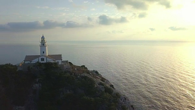 日出时马略卡岛岩崖灯塔的空中轨道视频素材